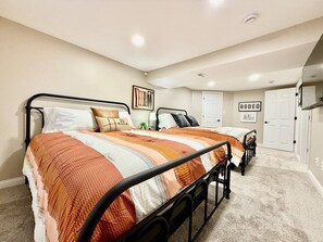 Un dormitorio con cama, dos mesitas de noche, un armario y una puerta.