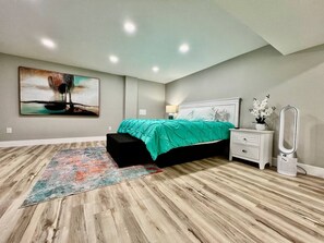 Une chambre à coucher avec un lit, une table de chevet, une lampe et un miroir.