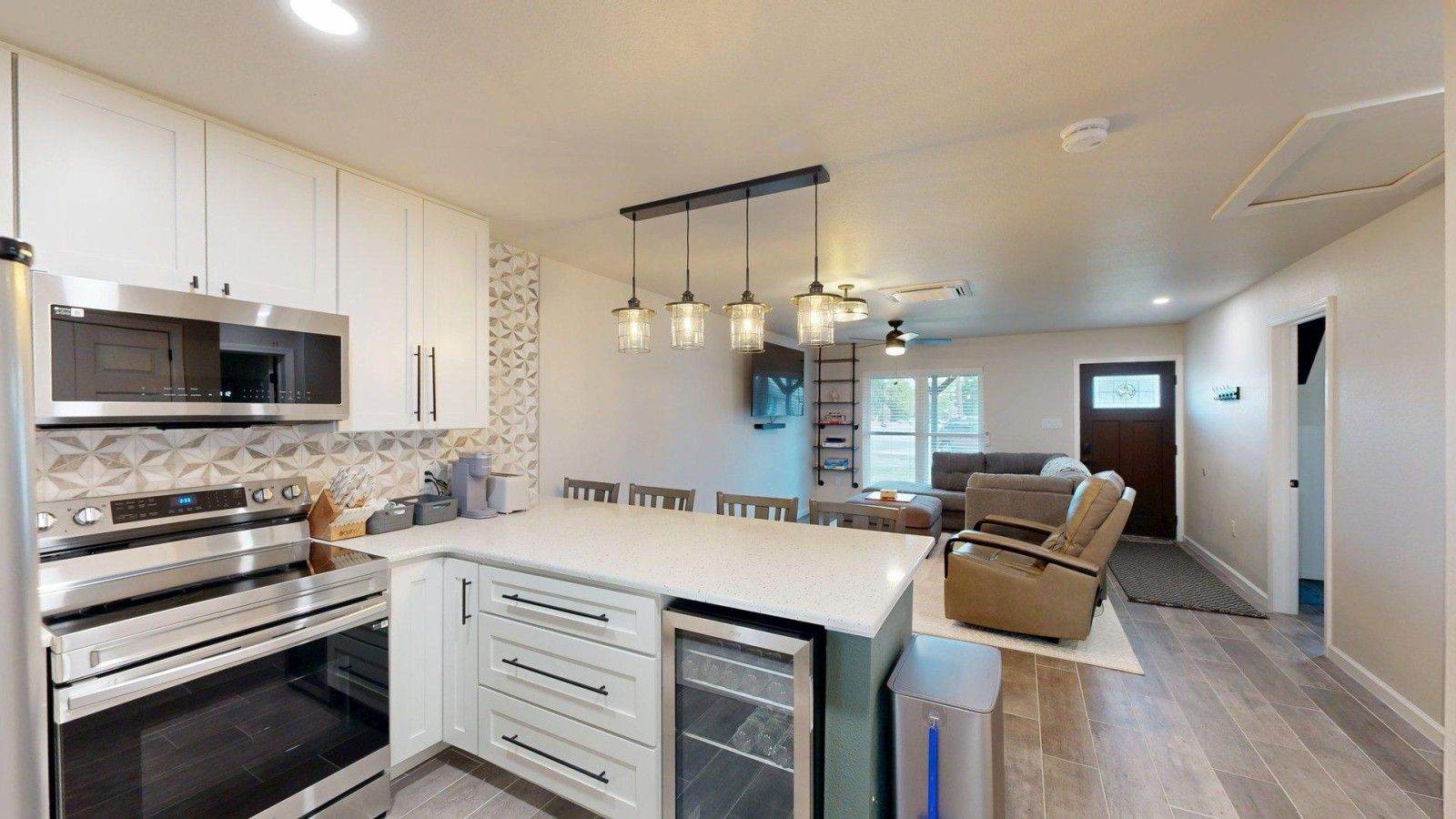 A modern kitchen with built-in appliances, a dining area with a large island, and a cozy seating area with a recliner.