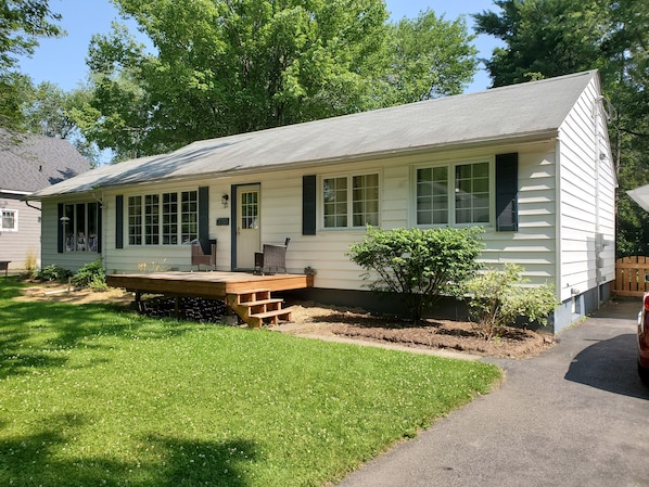 A single-story house with a front porch, a small garden, and a wooden deck. - Fredericton Home Close to Downtown in Peaceful Neighbourhood (Fredericton)