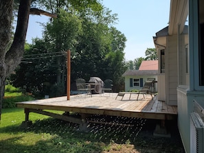 A backyard with a wooden deck, a grill, and outdoor furniture. - Fredericton Home Close to Downtown in Peaceful Neighbourhood (Fredericton)