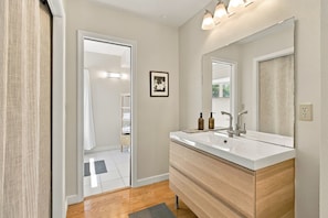Une salle de bain moderne avec un grand miroir, deux vasques et un meuble-lavabo en bois.
