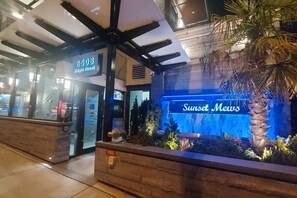 Ein Hotel Eingang mit einem Schild für '6508 Knight Street' und einem Schild für 'Sunset News'.