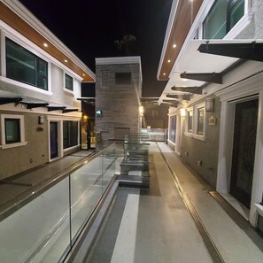 A corridor with glass railings, a central walkway, and buildings on either side. - Beautiful Luxurious 3 Bed Townhouse (Vancouver)