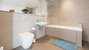 Et stilfuldt badeværelse med toilet, vask og brusebad.