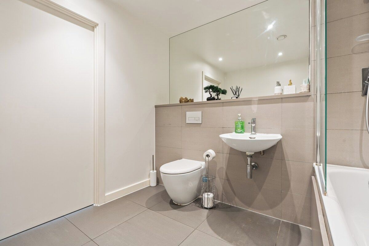 Une salle de bain moderne équipée de toilettes, d’un lavabo et d’un espace douche.