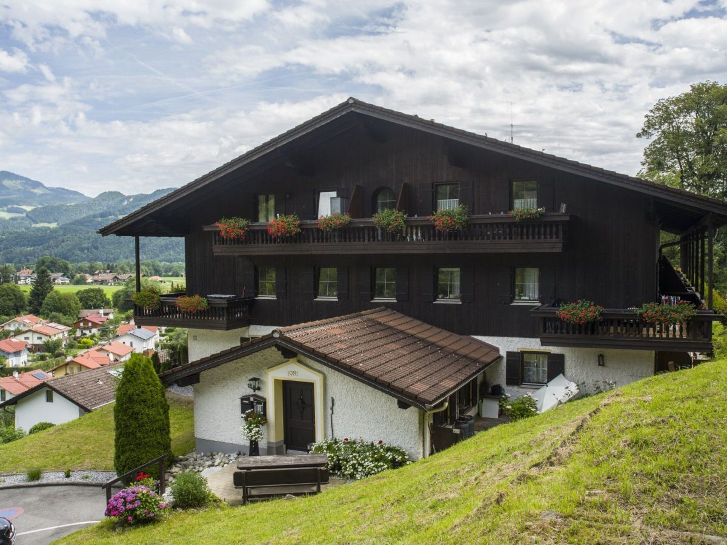 Un bâtiment à deux étages doté d’un balcon, d’une petite dépendance attenante et offrant une vue sur le paysage environnant.