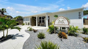 Ein Gebäude mit einem Schild, auf dem 'Casa Blanca Cocoa Beach' steht, und einer Webadresse.