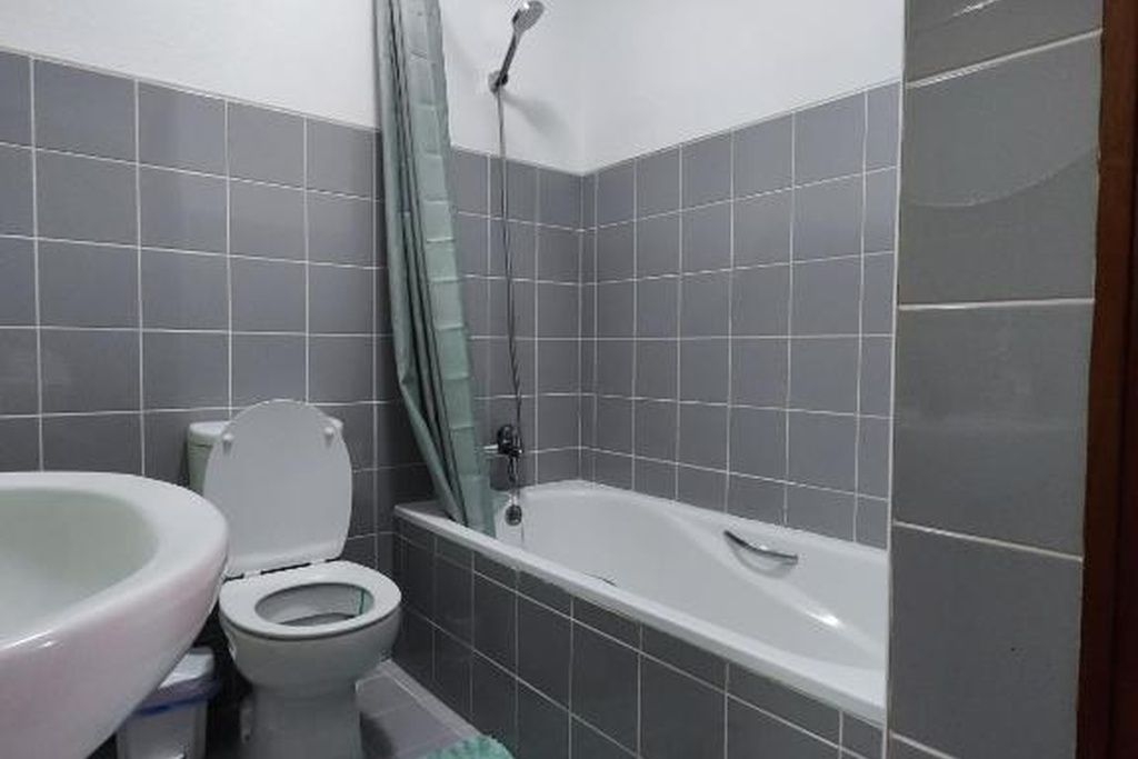 Une salle de bain avec des toilettes, un lavabo et une baignoire.