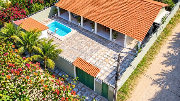 En bostadsfastighet med en swimmingpool, en täckt uteplats och en grön grind med texten ”NP 700”.