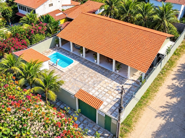 Il s’agit d’une propriété résidentielle dotée d’une piscine, d’un patio couvert et d’un portail vert portant l’inscription « NP 700 ».