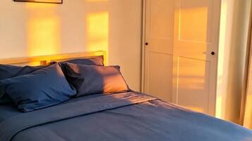 Ein Schlafzimmer mit Bett, Tür und einem an der Wand hängenden Bild.