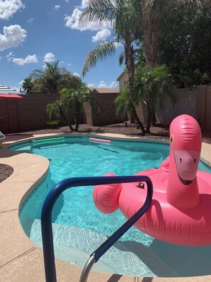 A swimming pool with clear blue water, surrounded by palm trees and a brick wall. - Pet Friendly-Priv. Pool-King Suite-Golf Nearby (San Tan Valley)