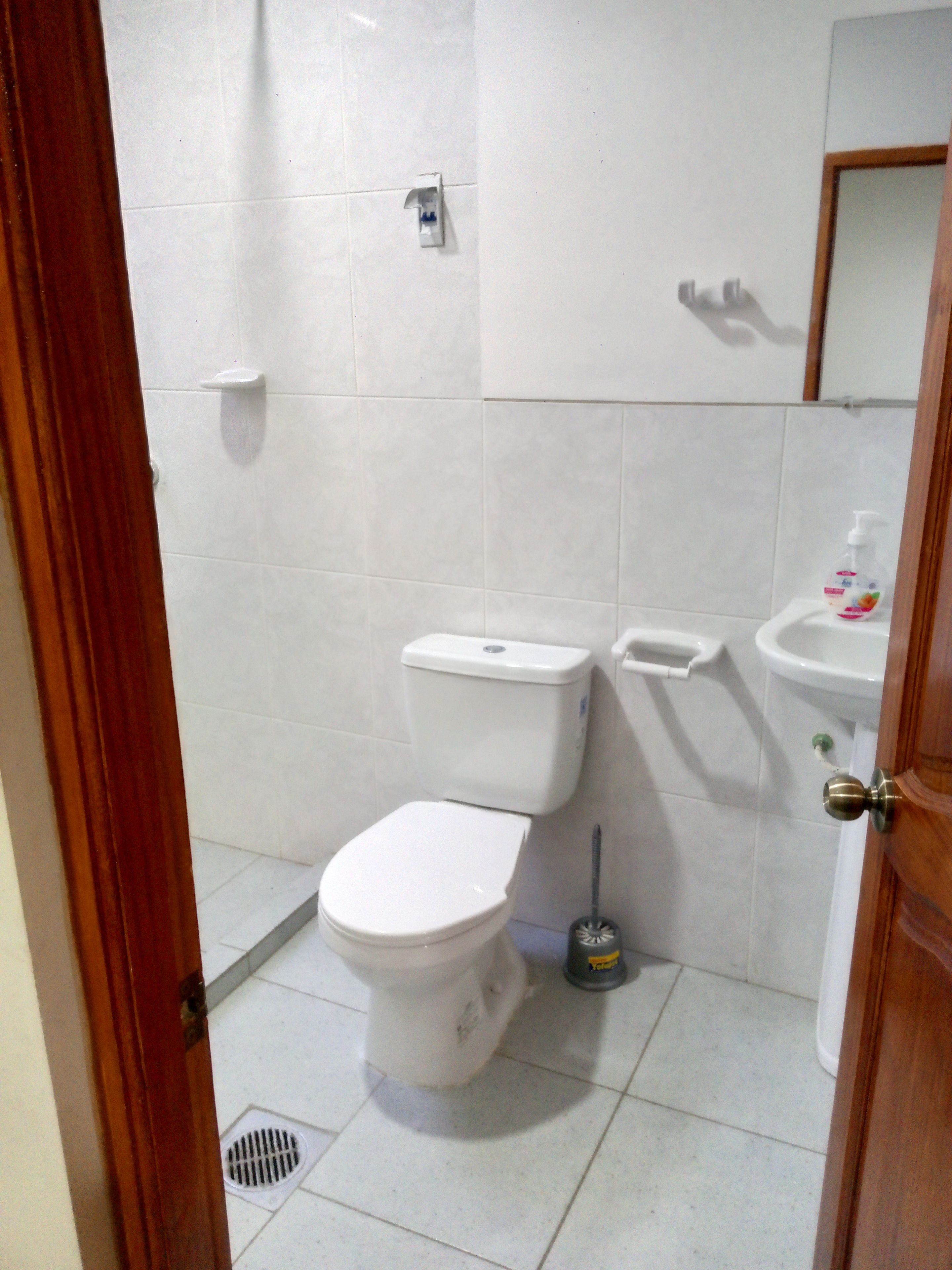 Un baño con inodoro, bidé y lavamanos.