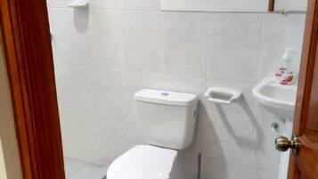 Un baño con inodoro, bidé y lavamanos.