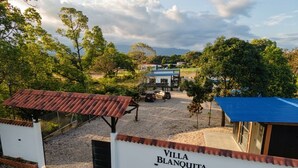 Une propriété privée, appelée « Villa Blanquita », dotée d’une allée en gravier, d’un espace de stationnement couvert et offrant une vue sur le paysage environnant.