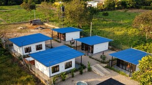 Un complexe résidentiel moderne composé de plusieurs maisons, chacune ayant un toit bleu et des murs blancs.