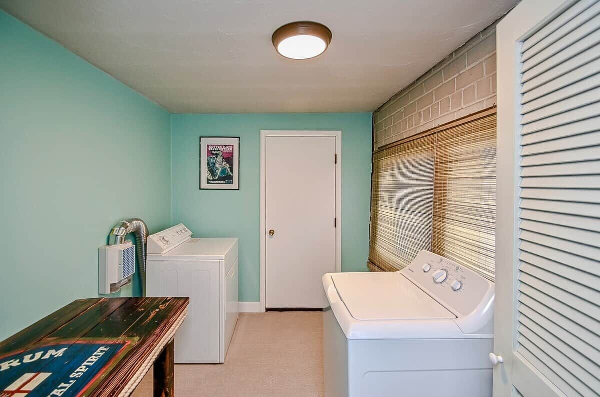 A laundry room with a washing machine, dryer, and a door.