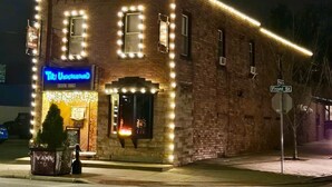 Un edificio in mattoni con un neon che riporta la scritta 'Tiki Underground' e un cartello stradale che indica 'Front St.'