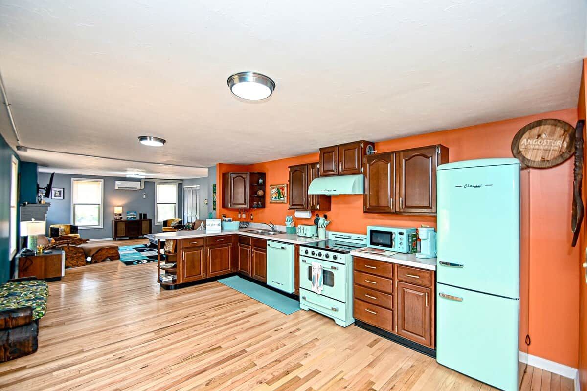 A kitchen with wooden cabinets, a refrigerator, and a stove.