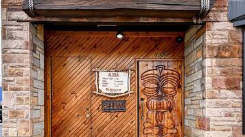 A wooden door with a sign above it that reads 'Tiki Underground Cocktail Lounge.'