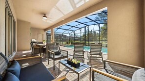 A covered outdoor patio with seating, a pool, and a view of the outdoors. - Windsor Renovated 10BR Home • Movie & Games Room (Kissimmee)