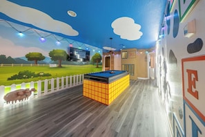 A room with a pool table, a white picket fence, and a mural of a landscape with trees and sheep. - Royal Magic Villa • 10BR at Windsor Resort (Kissimmee)