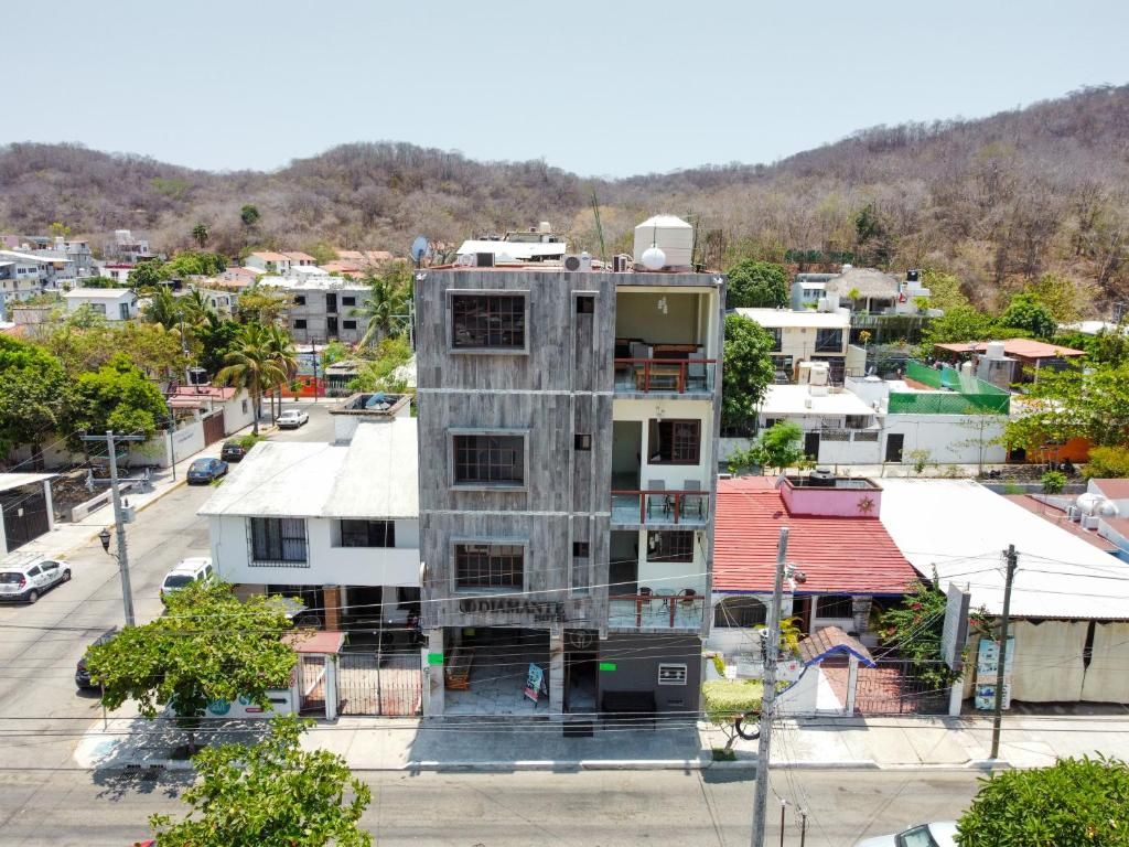A multi-story building with a commercial ground floor, surrounded by other buildings and greenery.