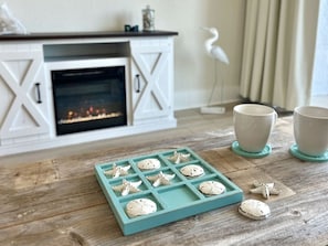 A kitchen area with a white cabinet, a teal tray with starfish-shaped cookies, and two white cups on a wooden table. - 1BR Oceanfront Suite, Wake Up to the Atlantic! (Myrtly Beach)
