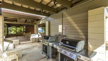 Un espace barbecue extérieur équipé de deux grils, d’une cuisinière à gaz et d’un évier.