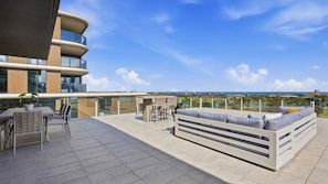 A rooftop terrace with a seating area, a table with chairs, and a view of the cityscape. - The Roy Luxury 3BR with Huge Entertainer's Terrace (Melbourne)