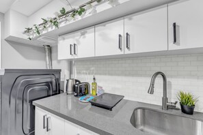 Una cocina moderna con armarios blancos, electrodomésticos de acero inoxidable y encimera de granito.