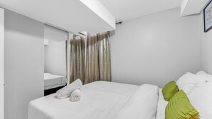 Hotellihuone, jossa on sänky, kylpyhuone ja peili.