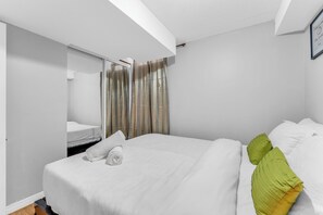 Una habitación de hotel con cama, baño y espejo.