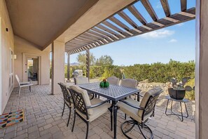 An outdoor patio with a table and chairs, a grill, and a view of a vineyard. - Southwest 3 bed 2 bath Home w/Patio/BBQ/Pool/Spa (Fountain Hills)