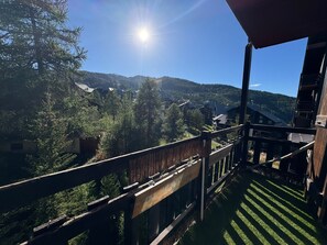 A wooden balcony with a view of a mountainous landscape. - Studio rénové 5 pers - avec balcon - Les Clématites - Risoul 1850 (Risoul)