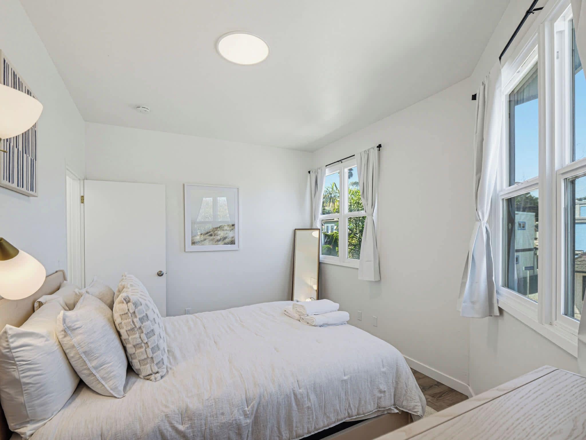 Une chambre à coucher avec un lit, une lampe de chevet, une fenêtre et une porte.