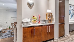 A hotel room with a kitchenette, a heart-shaped light fixture, a fruit bowl, and a painting on the wall. - The Landon Bay Harbor (Bay Harbor Island)