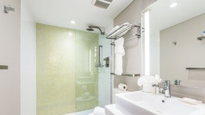 A modern bathroom with a shower, toilet, and sink. - The Landon Bay Harbor (Bay Harbor Island)