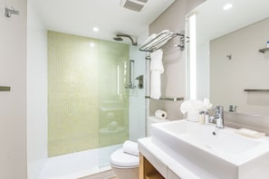Een moderne badkamer met douche, toilet en wastafel.