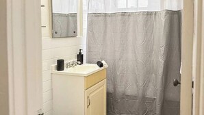 Un baño pequeño con inodoro, lavamanos y espejo.