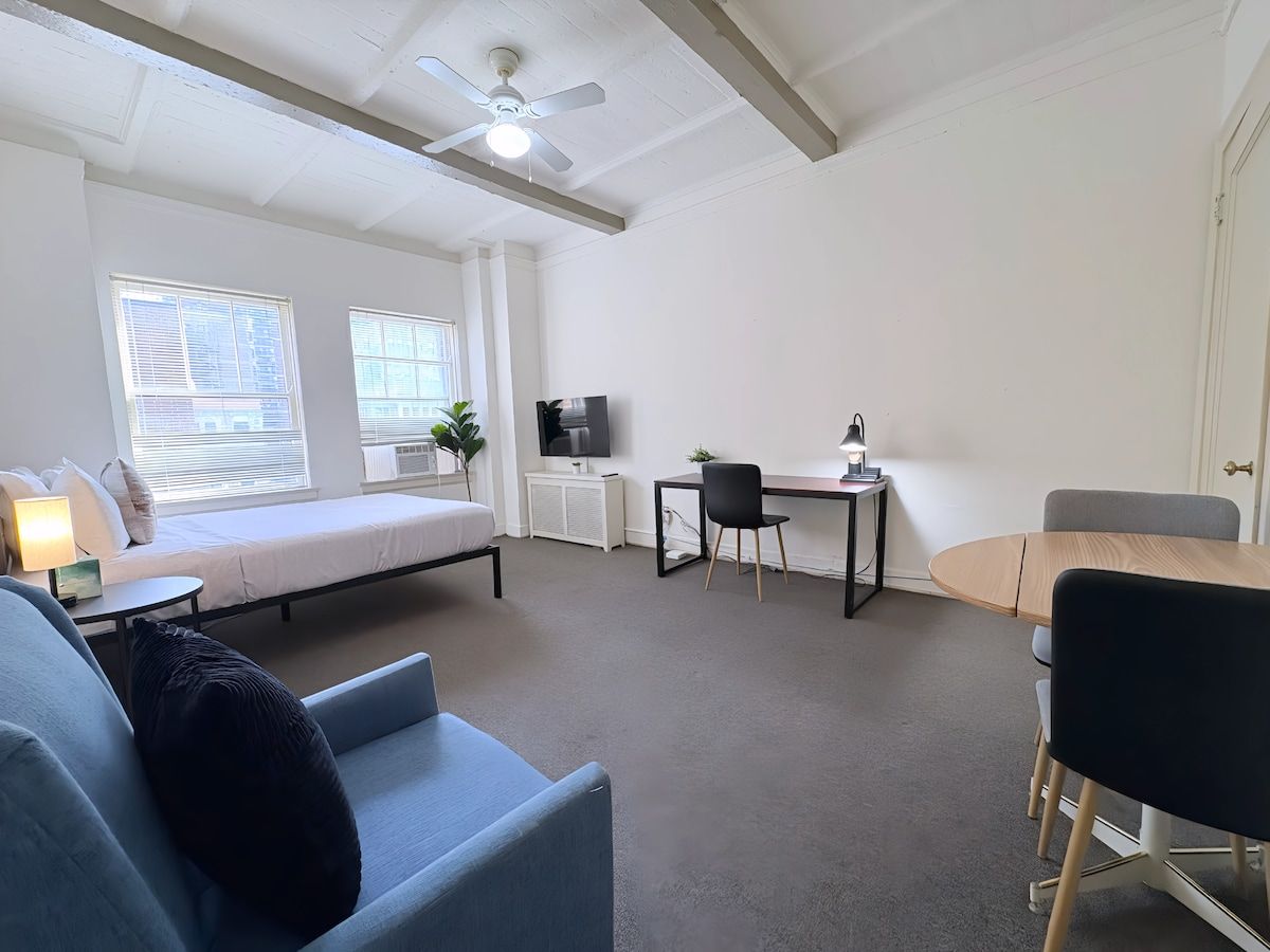 Un salon moderne comprenant un canapé, un lit, une table à manger et un téléviseur.