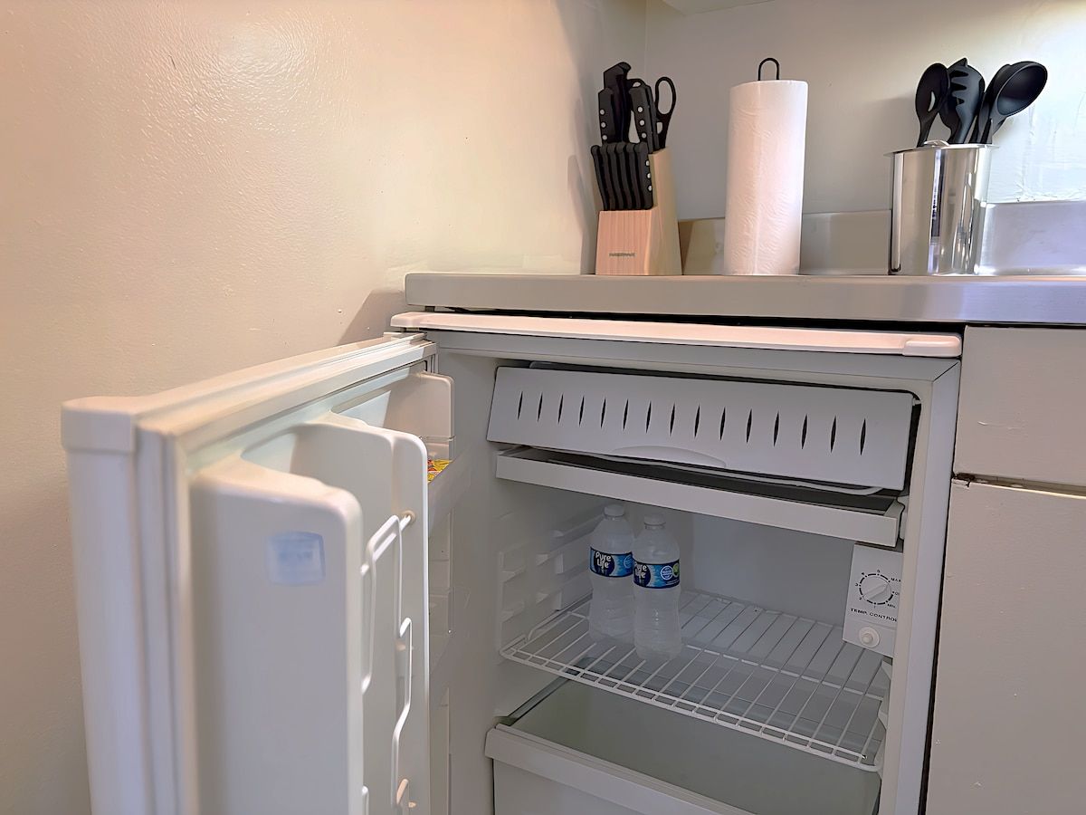 Eine Küche mit Kühlschrank, Mikrowelle und Spüle.