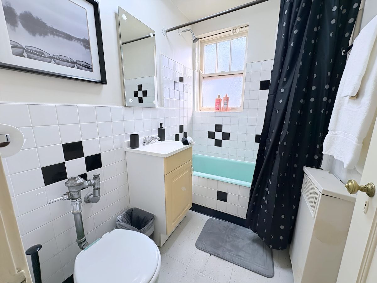 Ein Badezimmer mit Toilette, Waschbecken, Badewanne und einem Fenster mit Blick auf Boote.