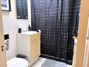 A compact bathroom with a toilet, sink, and cabinet. - Gold Coast Hideaway | Vintage & Inviting Studio (Chicago)