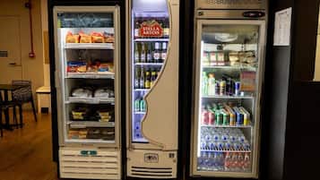 Three beverage vending machines with various drinks and snacks.