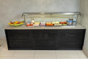 Ein Buffet mit verschiedenen Speisen und einem Wasserspender.