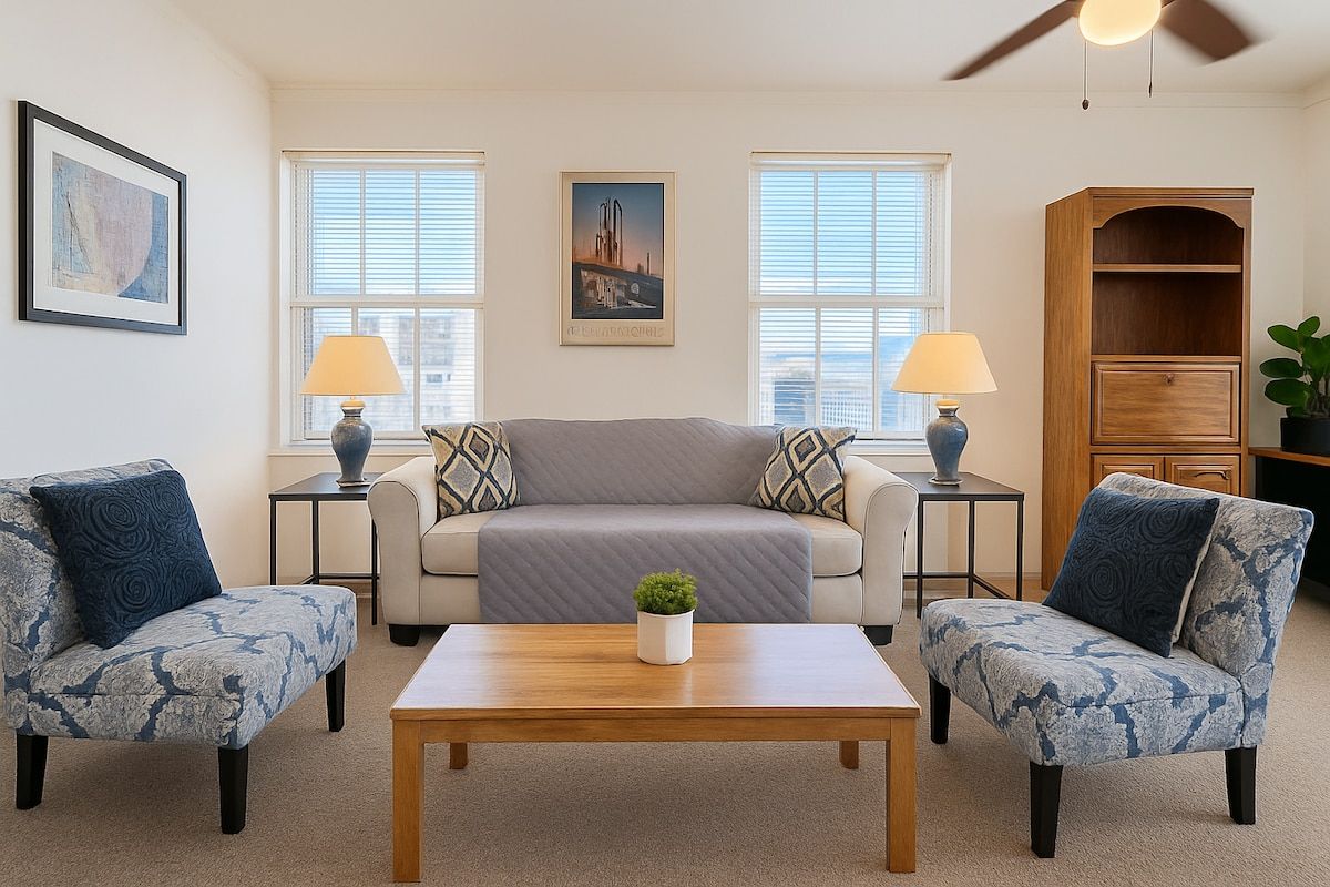 A living room with a sofa, two armchairs, a coffee table, and a bookshelf.