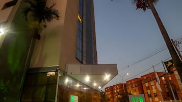 A modern building with a prominent vertical structure and a well-lit entrance.