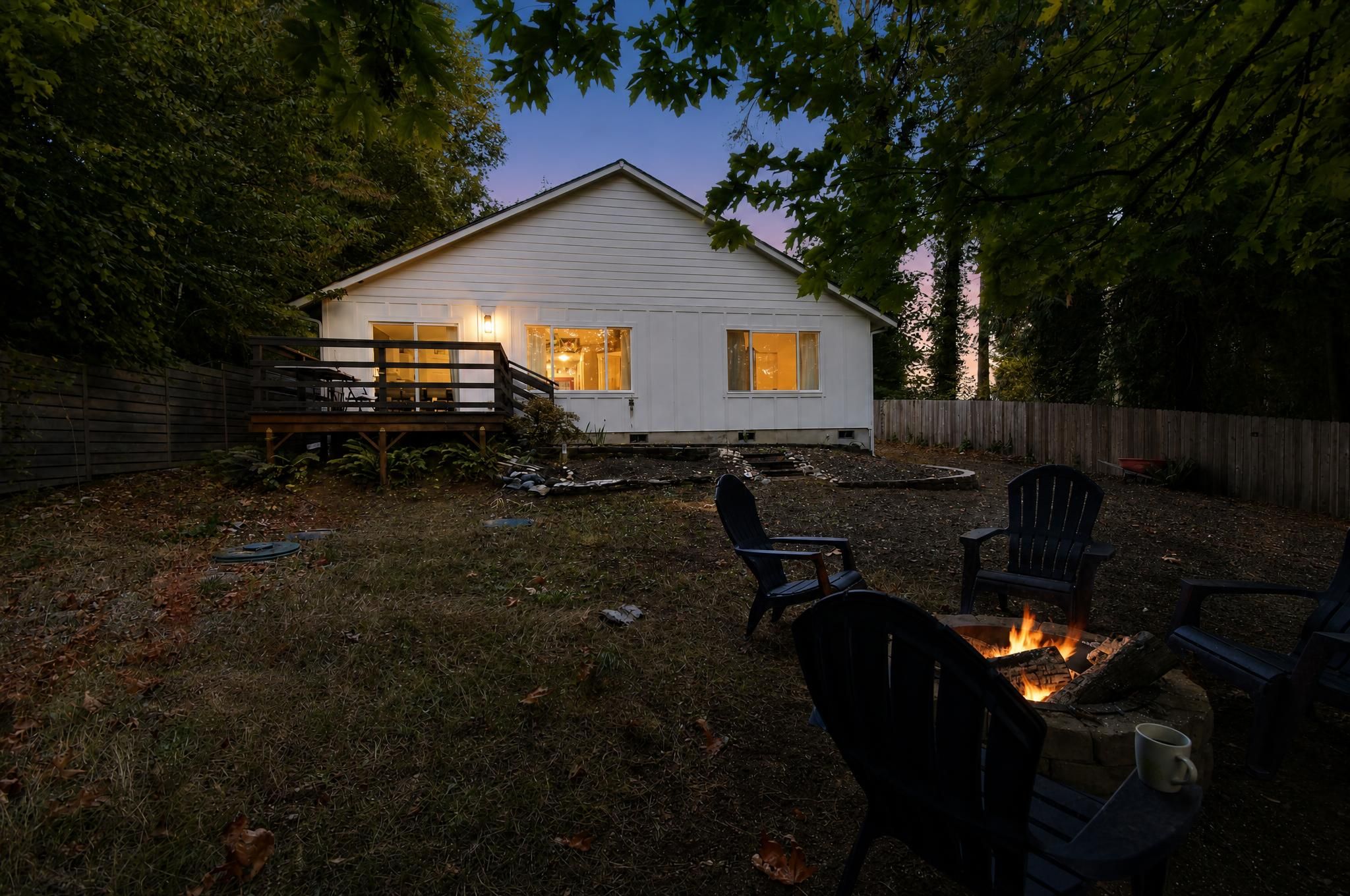 A house with a deck, a fire pit, and outdoor seating.